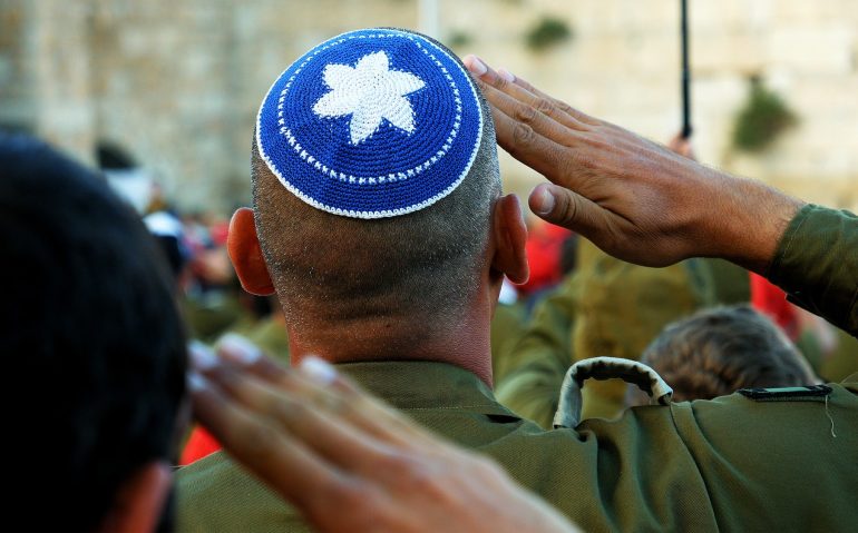 Israeli soldier military man saluting to the Western wall in Jerusalem