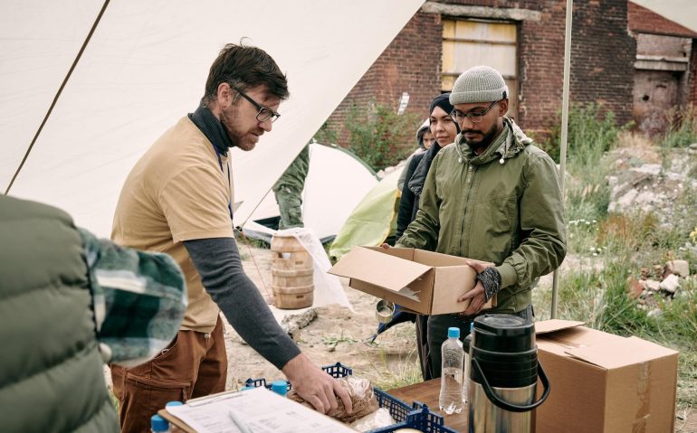 Volunteer Giving Food To Refugees